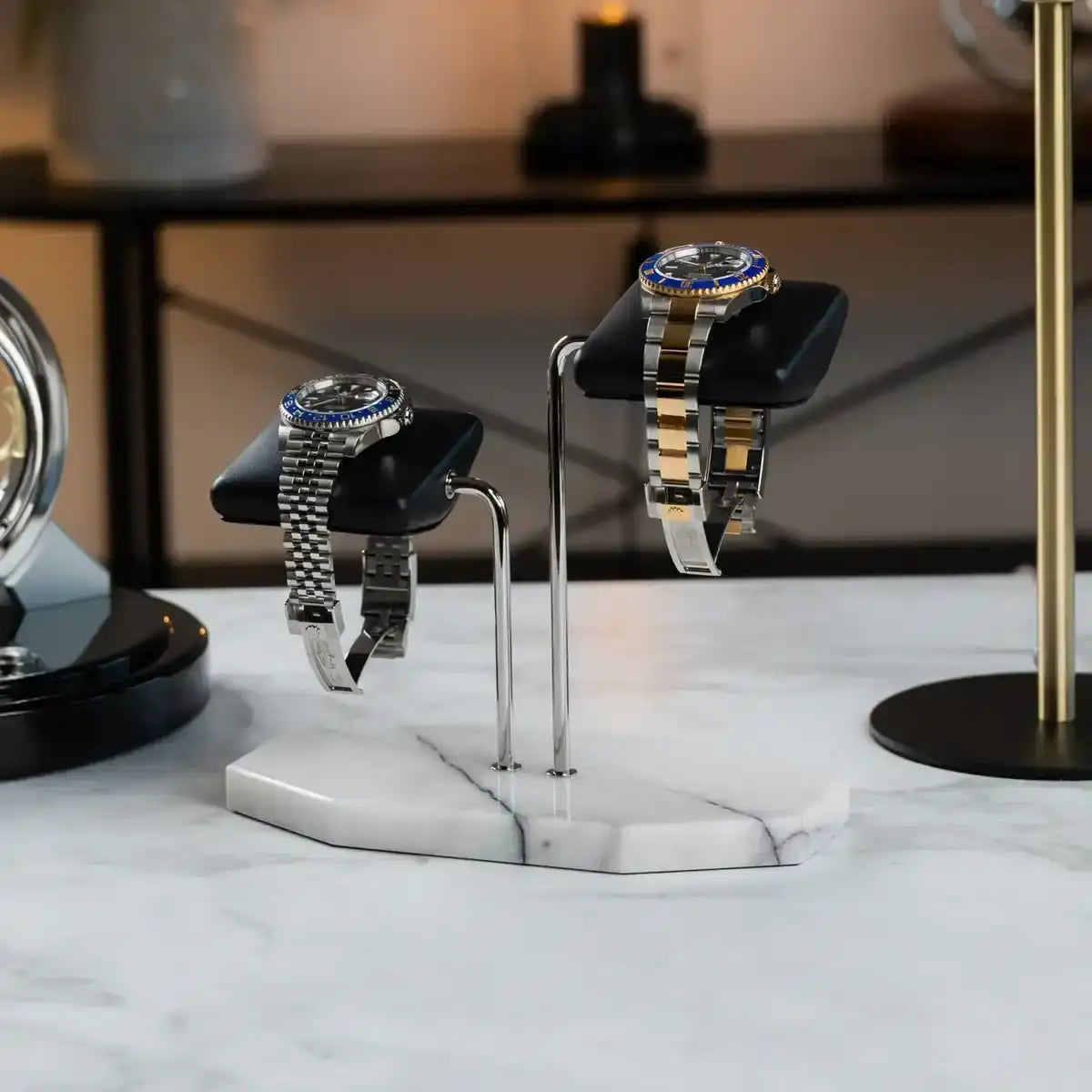 Two watches on a marble stand.