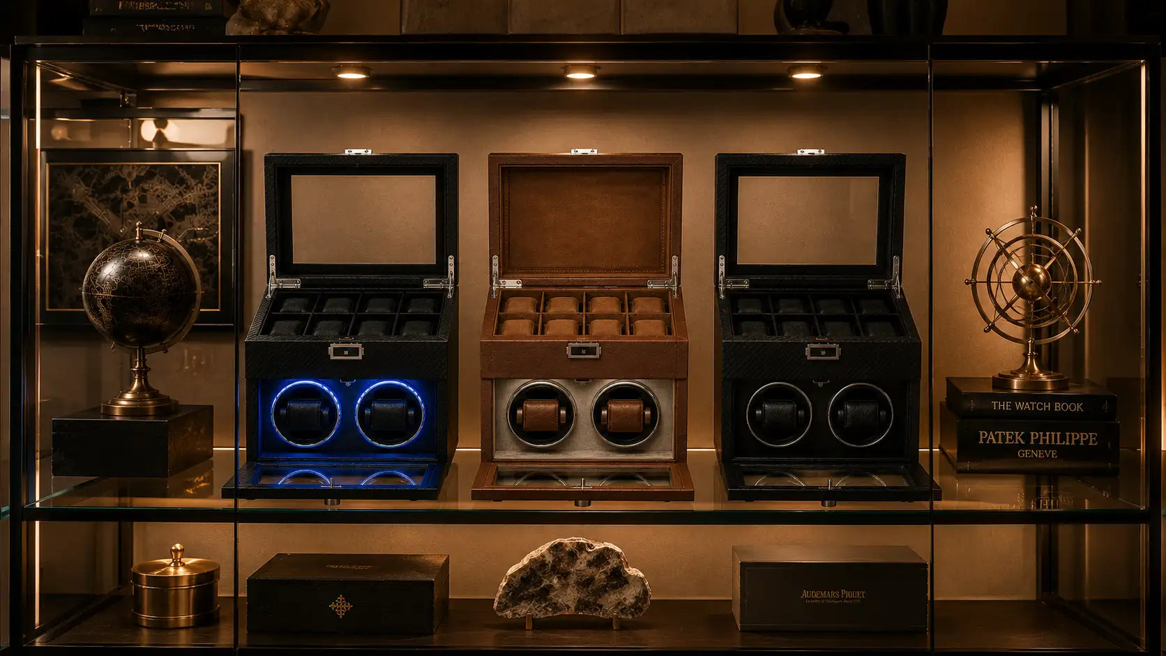 Three watch winder boxes, one black with blue led lighting, one wooden brown with two rotating compartments, and another black model.