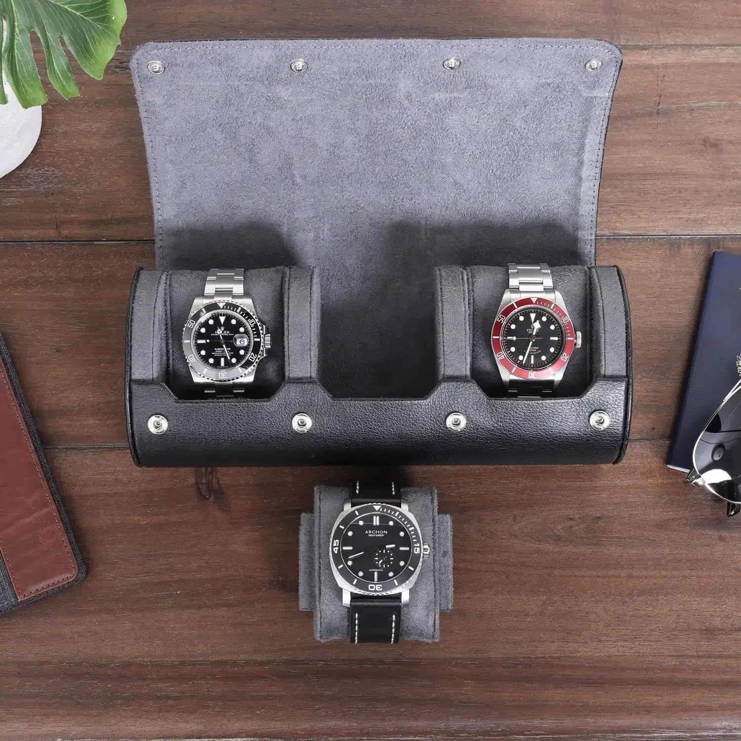 Three watches in a leather roll case.