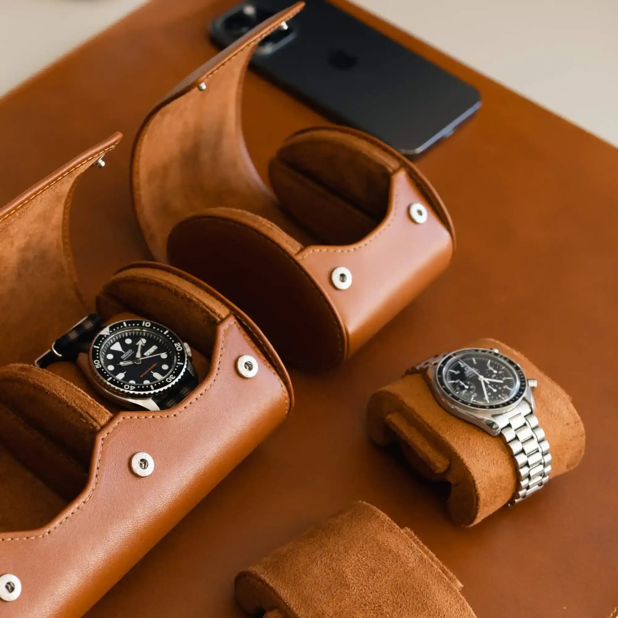 Brown leather watch cases with watches.