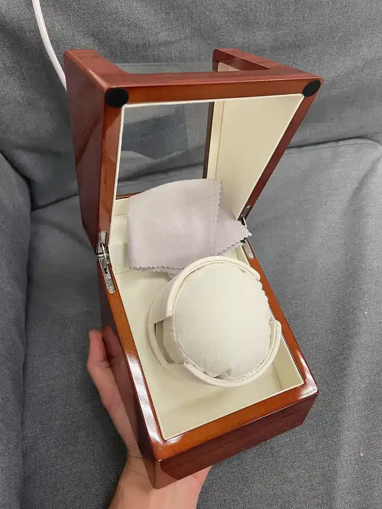 Open, glossy wooden watch winder.
