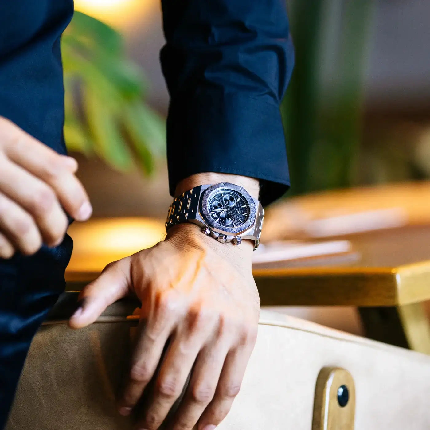 A sleek, silver-toned audemars piguet royal oak chronograph watch with a black dial and integrated bracelet.