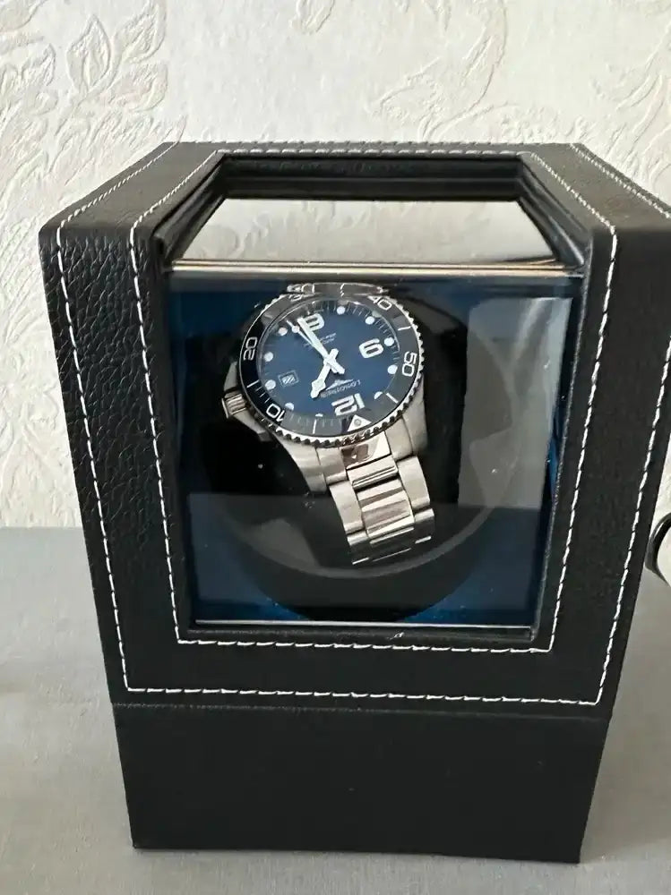 Blue-faced watch in a black leather winder.