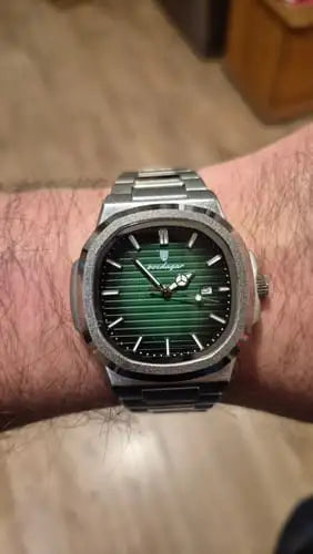 A sleek stainless steel watch with a vibrant green striped dial and silver-toned hands, featuring the brand name ’lindberg’ on its face.
