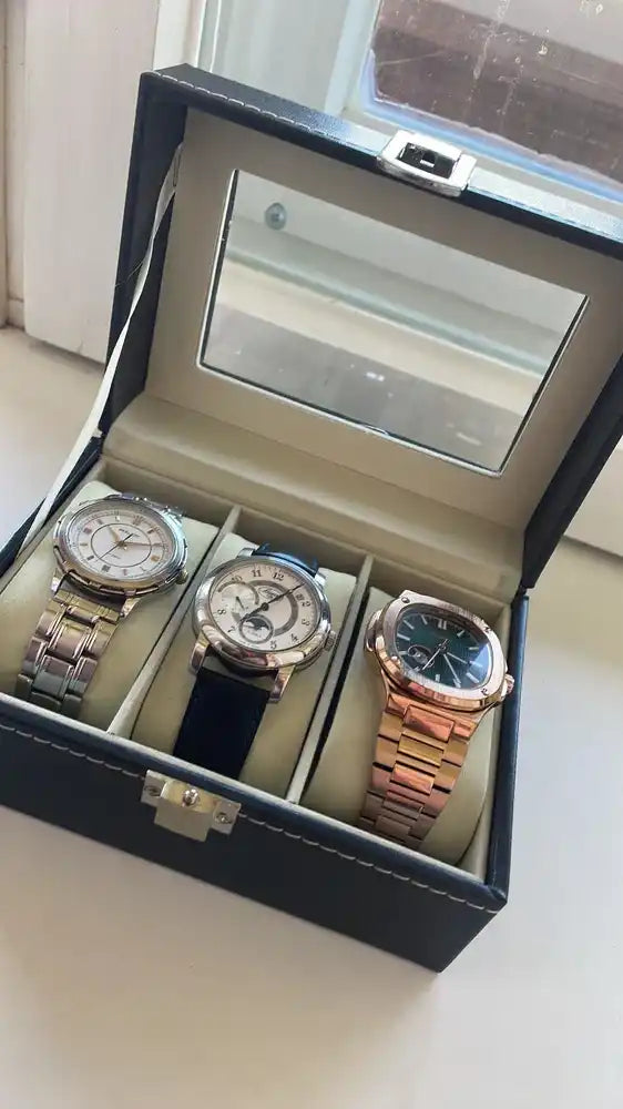 Three watches in a black leather box.