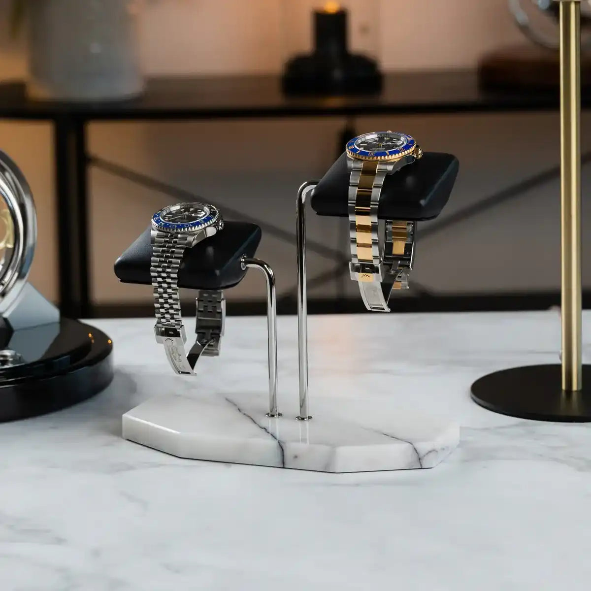 Two watches on a marble stand.